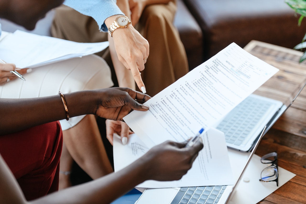 two woman looking paper in office